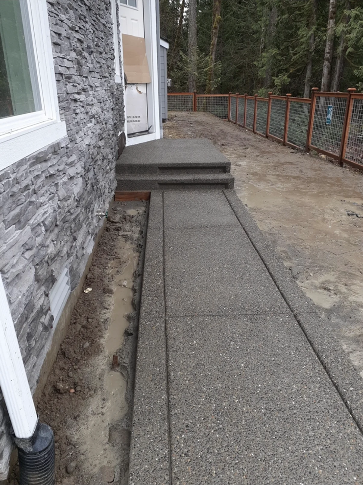 Exposed aggregate walkway leading to matching concrete entry steps