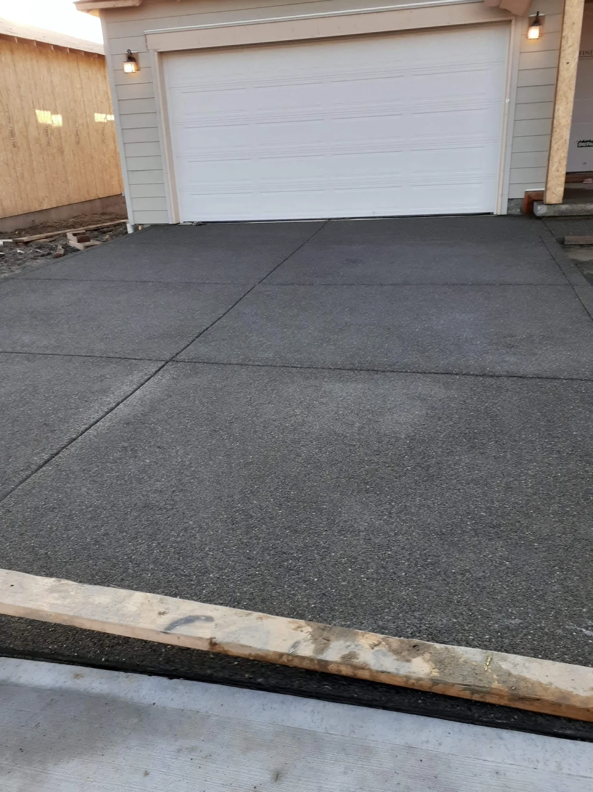 Exposed aggregate driveway in front of a white garage door