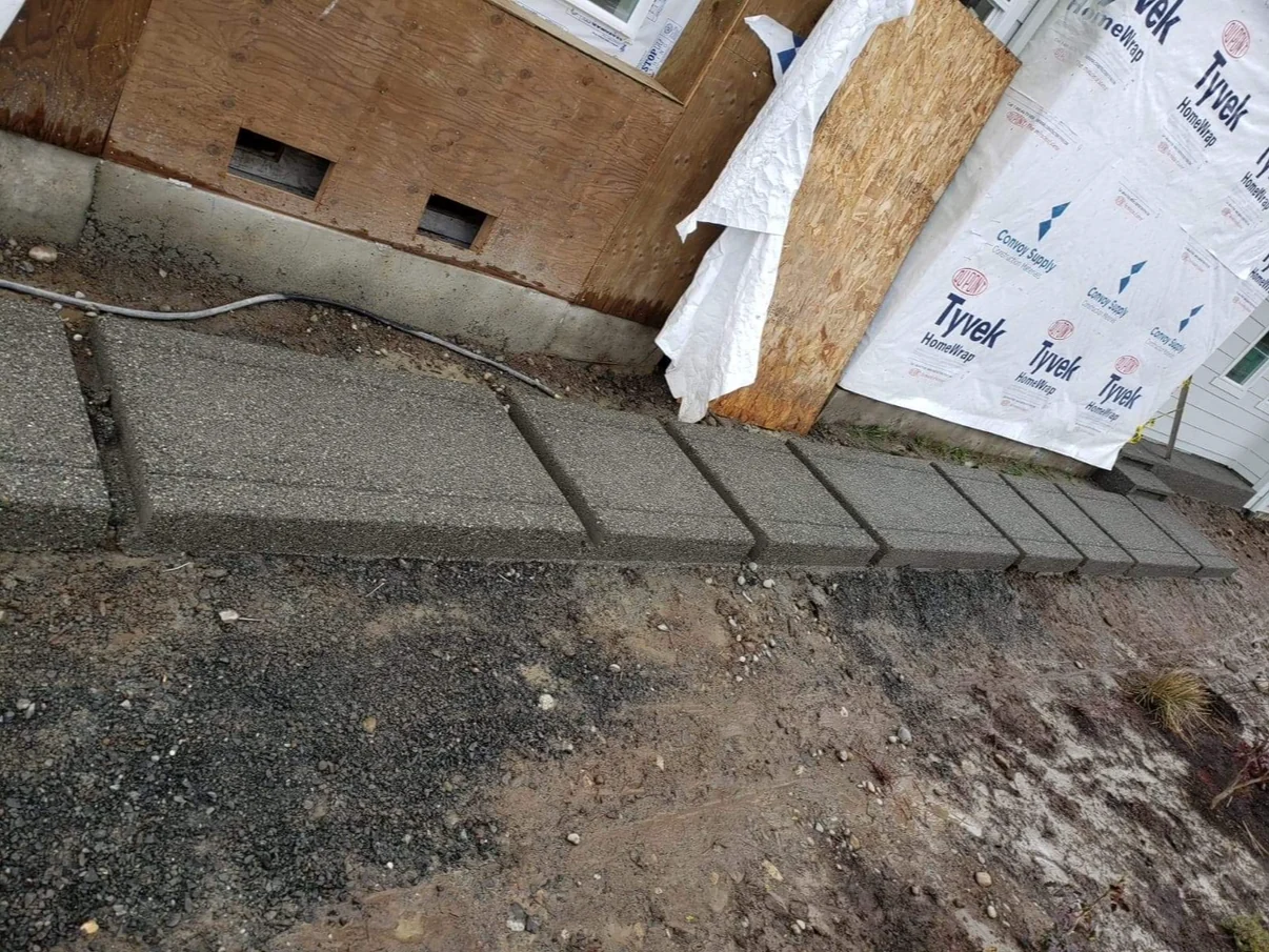 Exposed aggregate concrete path with individual stepped sections beside a home