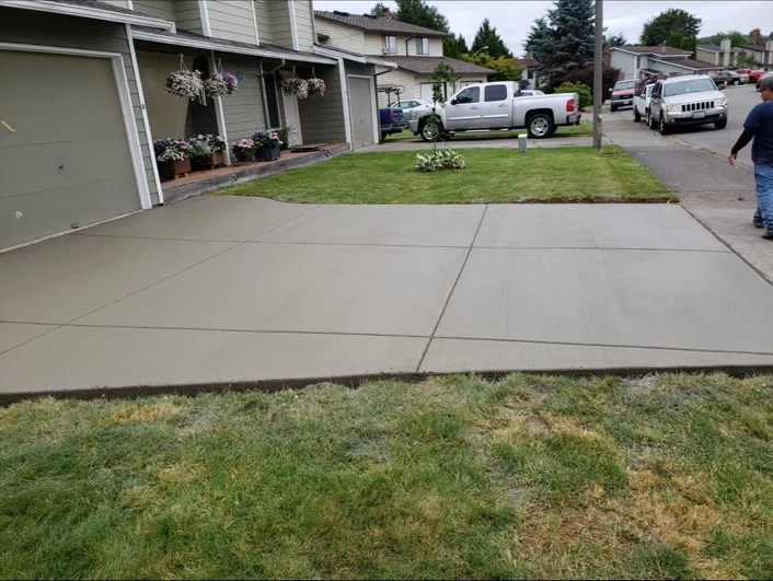 Concrete patio alongside a home and lawn