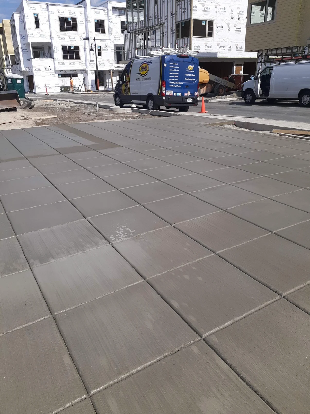Broad concrete approach with square joints and visible broom texture